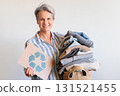 Gray haired woman with pile of clothes and recycling reusing signboard isolated on white background 131521455