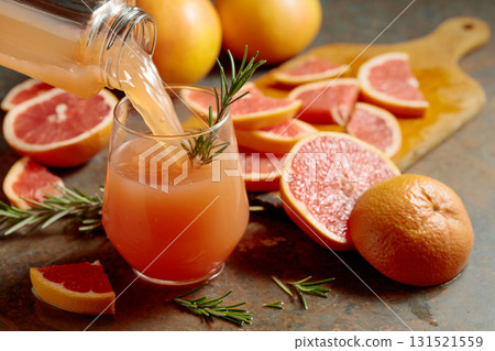 Grapefruit juice is poured into a glass. 131521559