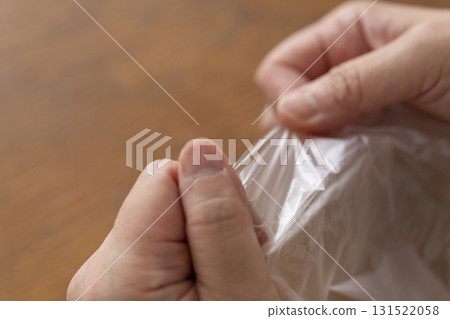 Senior woman's hands are so dry she can't open a plastic bag Senior woman's hands are so dry she can't open a plastic bag 131522058
