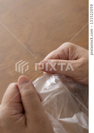 Senior woman's hands are so dry she can't open a plastic bag Senior woman's hands are so dry she can't open a plastic bag 131522059