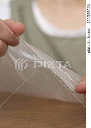 Senior woman's hands are so dry she can't open a plastic bag Senior woman's hands are so dry she can't open a plastic bag 131522066