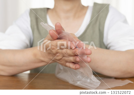 Senior woman's hands are so dry she can't open a plastic bag Senior woman's hands are so dry she can't open a plastic bag 131522072