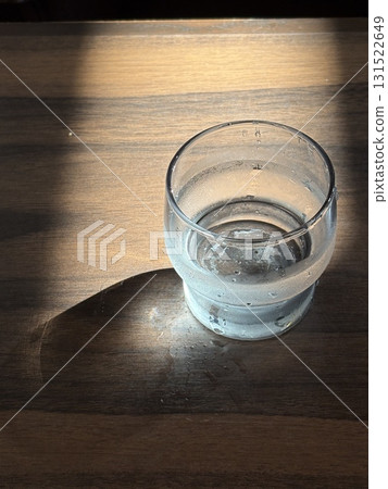 陽光透過窗戶，玻璃杯裡的水，桌上的影子 131522649