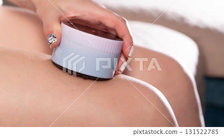The girl gives herself an anti-cellulite relaxing massage with a portable vacuum massager, flabbiness and elasticity of the skin. The girl gives herself an anti-cellulite relaxing massage with a portable vacuum massager, flabbiness and elasticity of the skin. 131522785