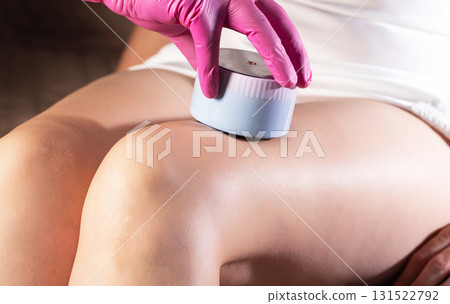 The hand of a cosmetologist makes an anti-cellulite massage with a portable vacuum massager, close-up, effective The hand of a cosmetologist makes an anti-cellulite massage with a portable vacuum massager, close-up, effective 131522792