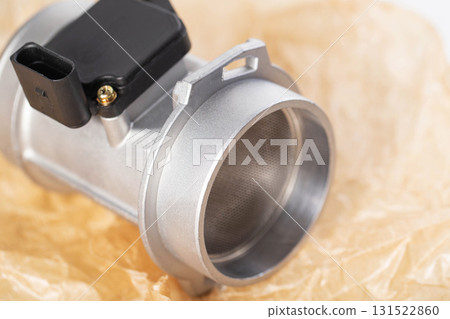 New car mass air flow sensor on brown packaging, background. Industry, close-up 131522860