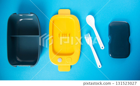Modern lunch box for storing food on blue background. Concept set of box fork and spoon. Nutrition at work, close-up 131523027