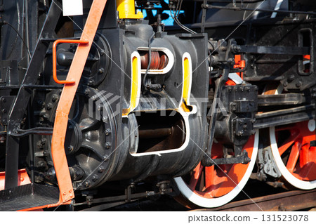 Large metal wheels of a steam locomotive transmitting traction from the locomotive to the rails, industry, close-up Large metal wheels of a steam locomotive transmitting traction from the locomotive to the rails, industry, close-up 131523078