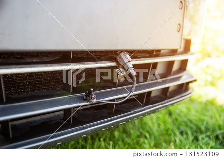 Black car outside air temperature gauge against car bumper grille at sunset. Car air measurement concept. Copy space for text Black car outside air temperature gauge against car bumper grille at sunset. Car air measurement concept. Copy space for text 131523109