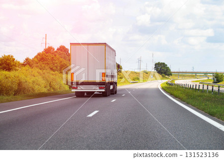 A modern semi-trailer truck transports cargo along a highway on a sunny day. Concept of payment for cargo transportation, price for freight. Copy space for text, industry 131523136