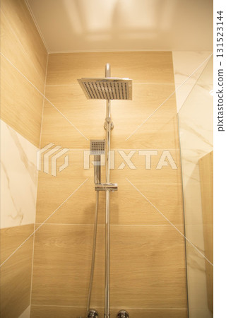 Modern chrome shower on brown porcelain tiles background. Modern bathroom interior. Copy space for text, cleanliness 131523144