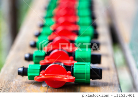 Multicolored plastic taps for assembling drip irrigation at the dacha, close-up Multicolored plastic taps for assembling drip irrigation at the dacha, close-up 131523401