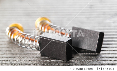 Electric motor brushes on gray background, macro, industry. Copy space for text 131523403