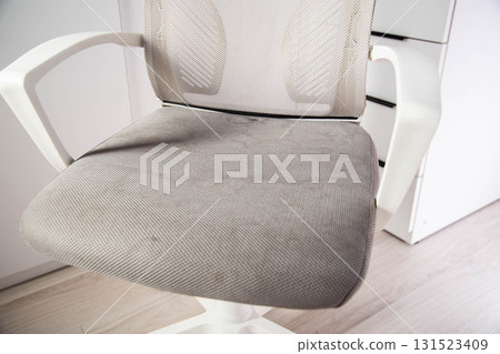 Dirty gray computer chair with stains on upholstery fabric, dry cleaning, close-up 131523409