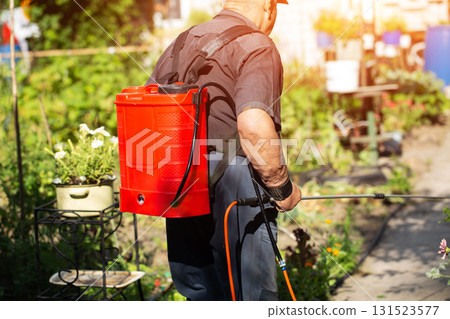 A summer resident treats plants in the summer from parasites. Plant protection from diseases, copy space for text, industry A summer resident treats plants in the summer from parasites. Plant protection from diseases, copy space for text, industry 131523577