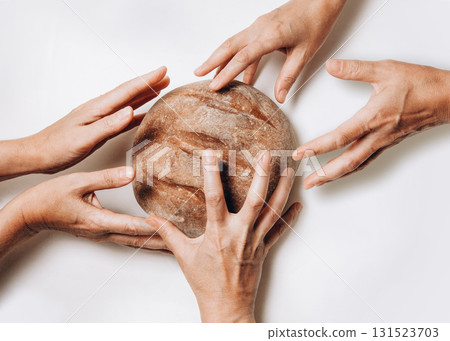 Hands reach for bread, highlighting hunger and food scarcity around the world today Hands reach for bread, highlighting hunger and food scarcity around the world today 131523703