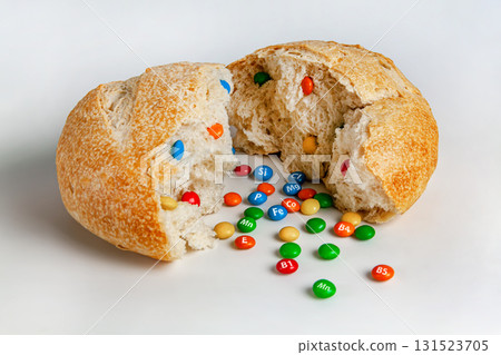 A round loaf of bread broken in half, vitamins are poured out of it. 131523705