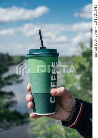 enjoying refreshing coffee cup by river on sunny day. vertical. closeup. 131523845