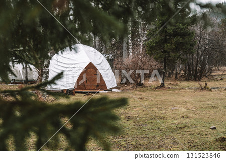 white dome tent in serene forest setting during early spring near calm landscape. closeup. 131523846