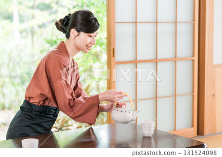 女旅館工作人員中井在溫泉旅館的客房倒茶 131524098