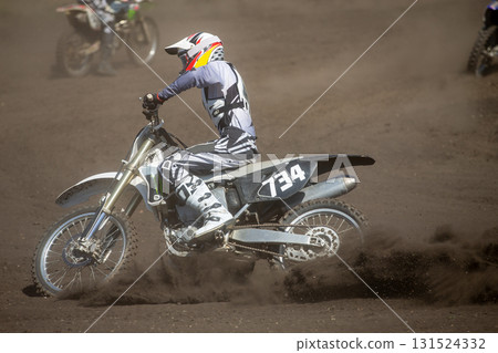 Motocross rider perform turn on dusty track 131524332