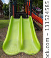 A Vibrant Green Double Slide on a Playground. 131524585