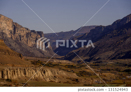 A high-mountain settlement at the foot of a rugged cliff with terracotta slopes A high-mountain settlement at the foot of a rugged cliff with terracotta slopes 131524943