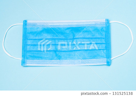 Blue medical mask, top view on blue background, healthcare, safety, and protective face mask concept Blue medical mask, top view on blue background, healthcare, safety, and protective face mask concept 131525138