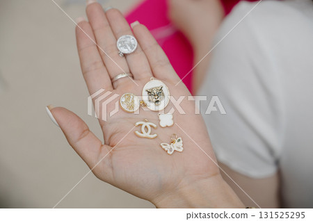 A woman's palm with a set of fashionable jewelry pendants. A woman's palm with a set of fashionable jewelry pendants. 131525295