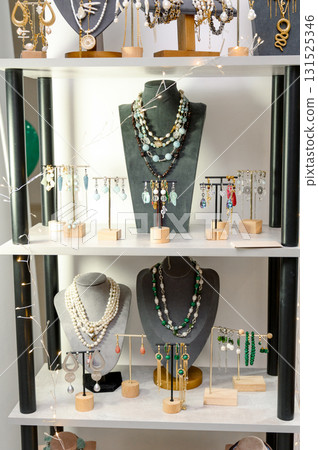 necklaces and earrings made of pearls and stones on mannequins on a store shelf necklaces and earrings made of pearls and stones on mannequins on a store shelf 131525346