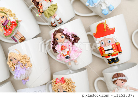 White mugs decorated with polymer clay fairy tale characters 131525372