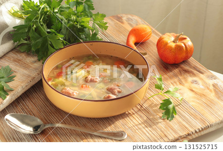 Traditional Italian minestrone soup with vegetables, sausage, and pasta, served in clay bowl on wooden board. Food and healthy lifestyle. Mediterranean cuisine. Traditional Italian minestrone soup with vegetables, sausage, and pasta, served in clay bowl on wooden board. Food and healthy lifestyle. Mediterranean cuisine. 131525715