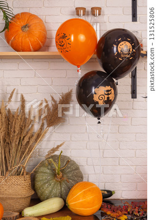 cozy kitchen decorated for Halloween. Two orange balloons float above sink. A carved pumpkin sits on the counter next to spider web decoration cozy kitchen decorated for Halloween. Two orange balloons float above sink. A carved pumpkin sits on the counter next to spider web decoration 131525806