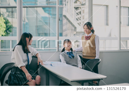 Junior high school girls talking by the window 131526170