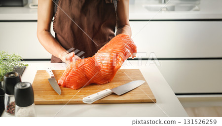 Women hold a raw salmon fillet 131526259