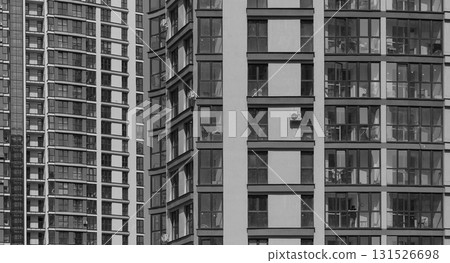 Closeup of modern high rise residential tower. Multiple windows and balconies form geometric facade 131526698