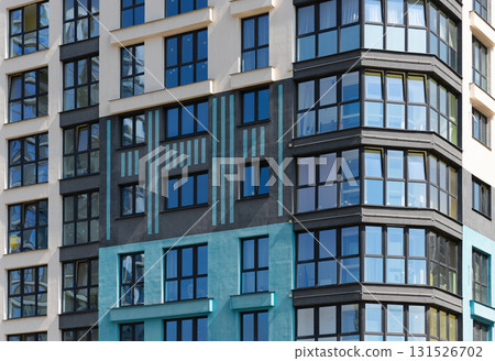 Closeup of modern highrise building facade. Multiple glass windows and balconies create geometric Closeup of modern highrise building facade. Multiple glass windows and balconies create geometric 131526702
