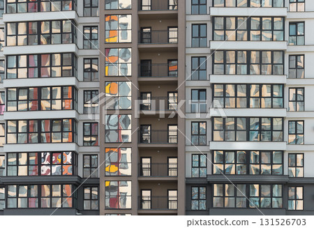 Closeup of modern multi storey condominium tower. Multiple glass windows and balconies create 131526703