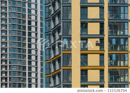 Closeup of modern multistorey residential building facade. Glass windows and balconies create Closeup of modern multistorey residential building facade. Glass windows and balconies create 131526704