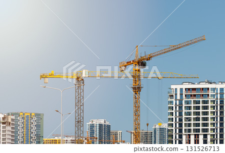 Construction cranes over tall high rise tower with steel framework and concrete structure in 131526713