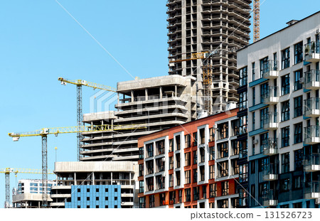 Construction of tall residential tower in urban metropolis. Unfinished structure with cranes, steel 131526723