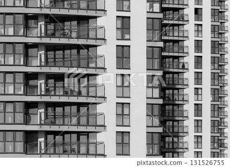 Geometric pattern of multiple glass windows on tall multistory residential block in metropolitan 131526755