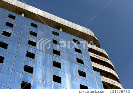 Highrise building under construction with glass facade and steel frame viewed from a low angle. 131526780