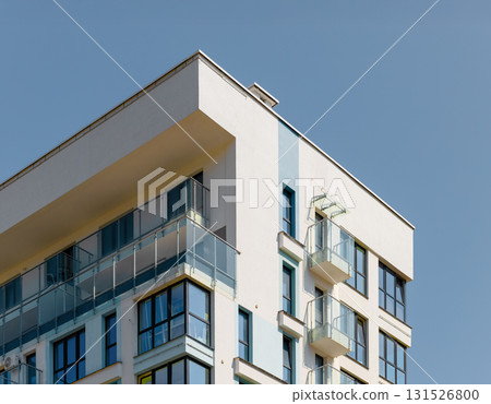 modern building with balconies and concrete facade under blue sky in metropolitan city. Contemporary 131526800