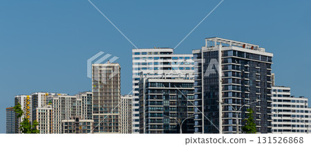 panoramic view of tall high rise building with glass windows and balconies in metropolitan district. 131526868