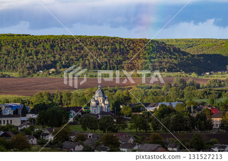 Church surrounded by lush hills and fields in a rural landscape with clear skies during golden hour in early summer Church surrounded by lush hills and fields in a rural landscape with clear skies during golden hour in early summer 131527213