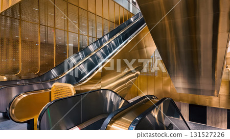 modern escalators in QSNCC with gold perforated panels and sleek design, contemporary transport in Bangkok venue highlighting futuristic luxury and elegant structure 131527226