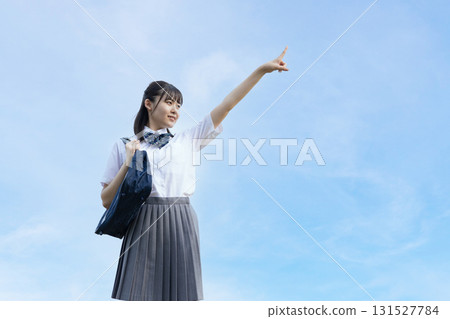 High school student pointing towards the blue sky 131527784