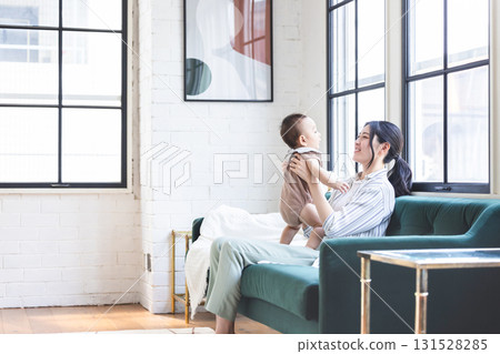 Baby and mother relaxing in the living room Baby and mother relaxing in the living room 131528285
