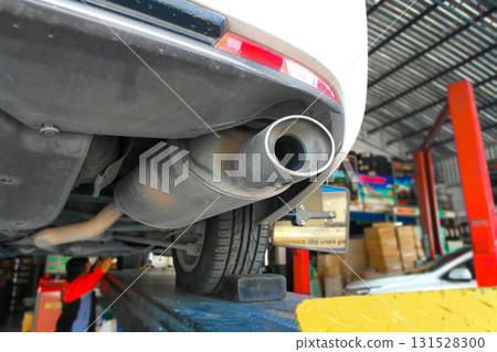Car exhaust pipe and muffler close up under vehicle on lift 131528300